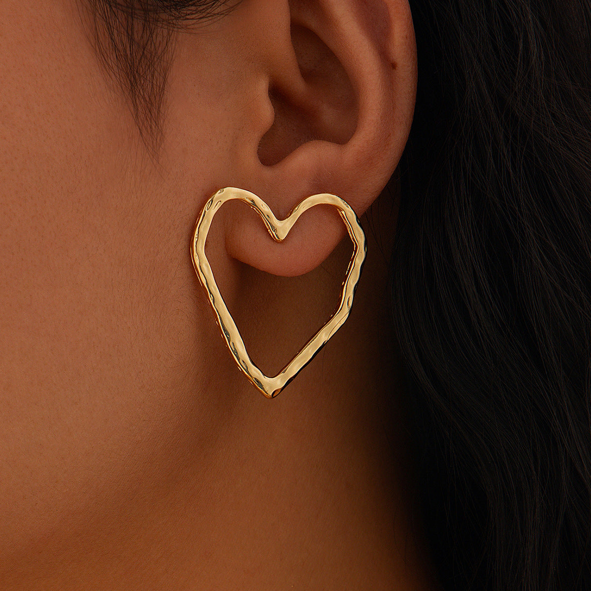 Gold heart-shaped dangle hoop earrings